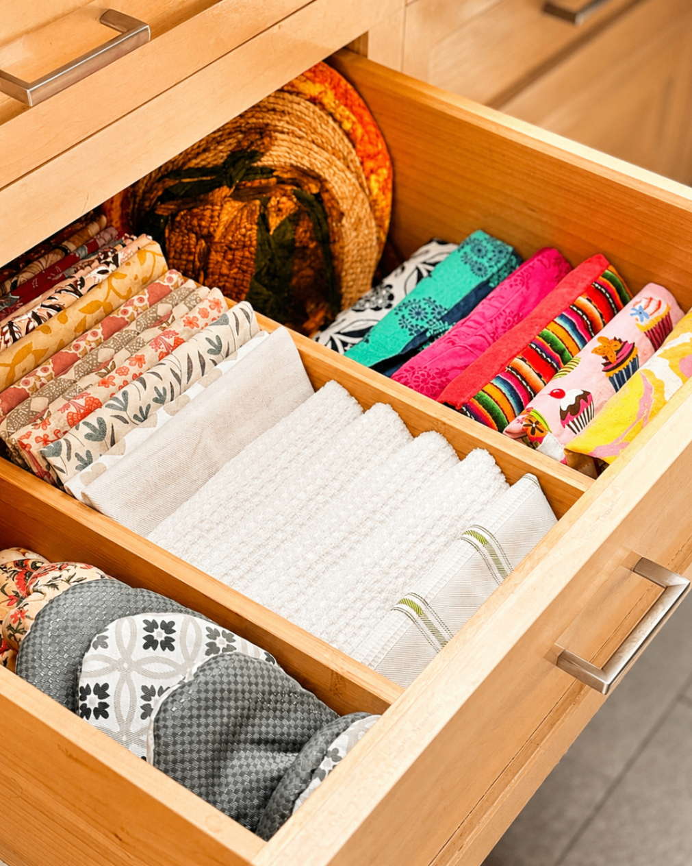Drawer with colorful folded linens sorted by section.